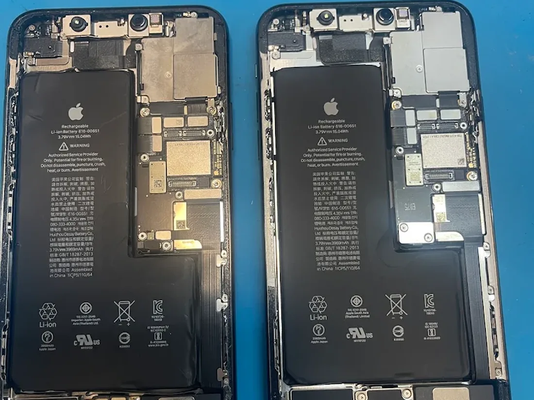 Două iPhone-uri deschise pe bancul de lucru din service