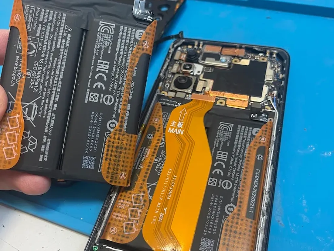 Schimb de baterie în lucru, cu telefonul demontat pe bancul de service